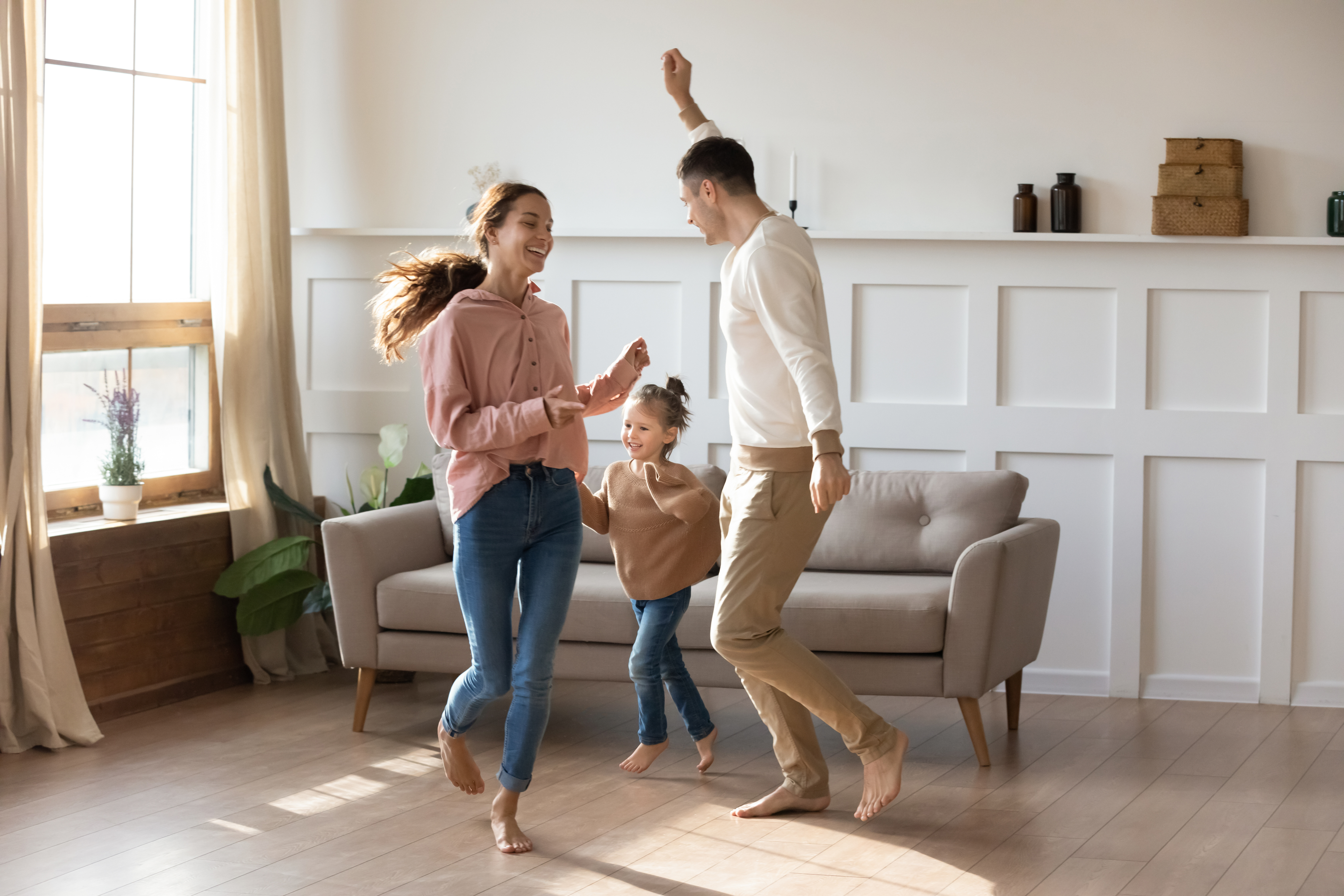 Child playing with her parents on underfloor heating floor