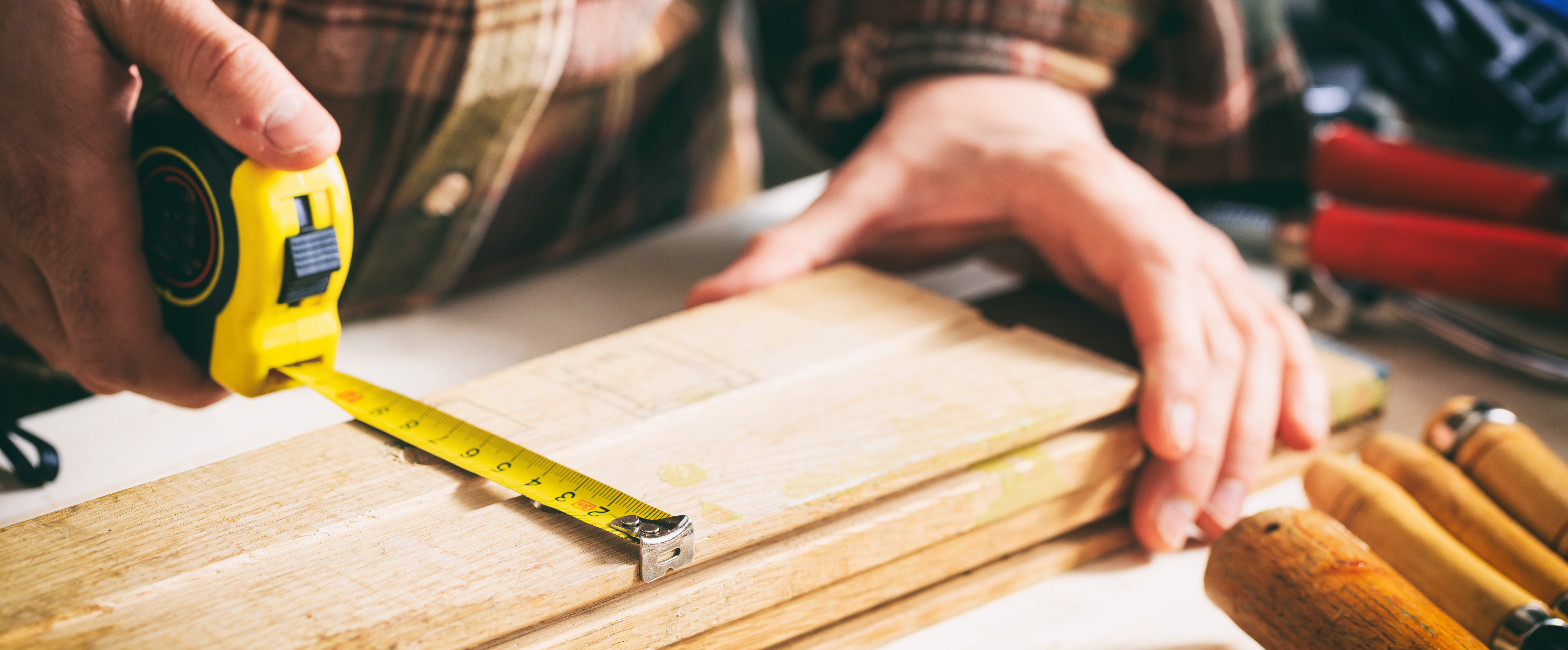 Builder using a tape measure for measurement